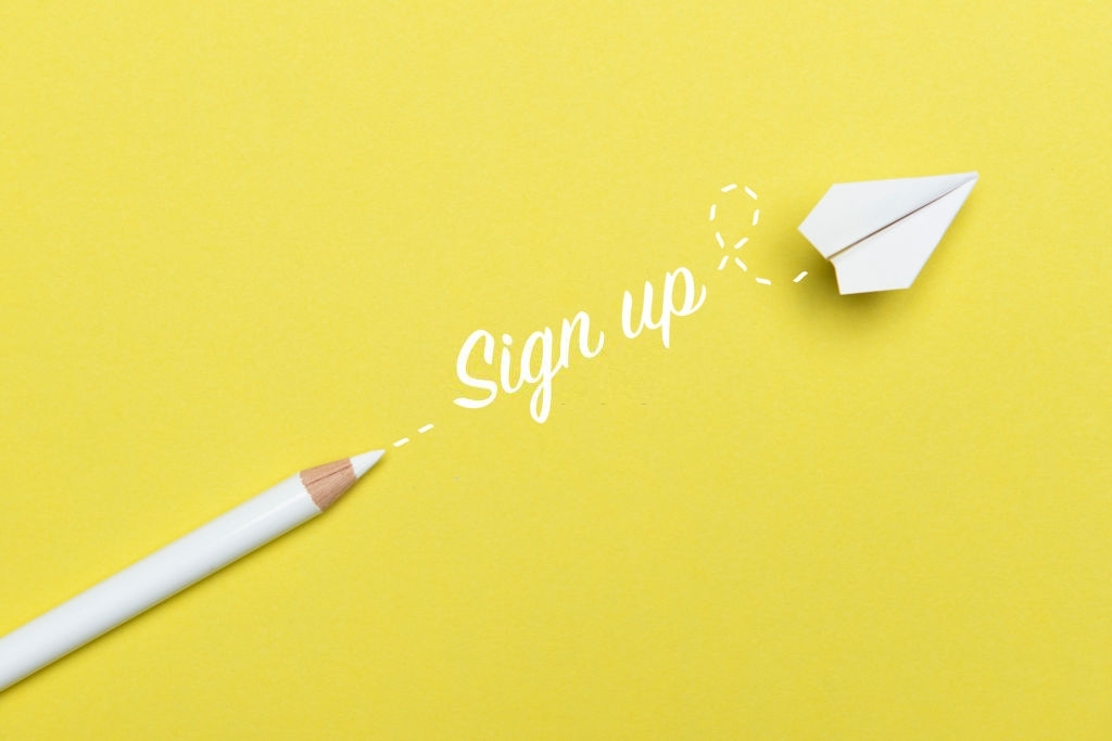 White pencil with Sign Up text and a white paper plane on yellow background.